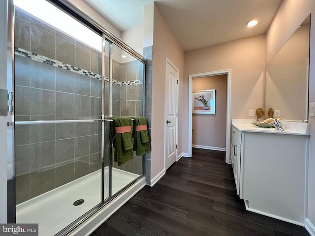 bathroom featuring a shower with door, vanity, and hardwood / wood-style flooring