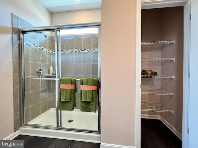 bathroom with a shower with door and hardwood / wood-style flooring