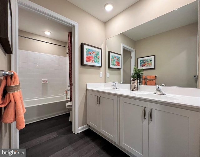 full bathroom with toilet, vanity, wood-type flooring, and bathing tub / shower combination