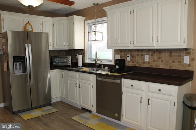 kitchen featuring sink, stainless steel appliances, white cabinetry, and tasteful backsplash