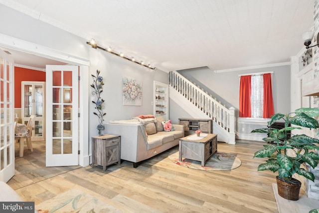 living room with crown molding, stairway, wood finished floors, and french doors