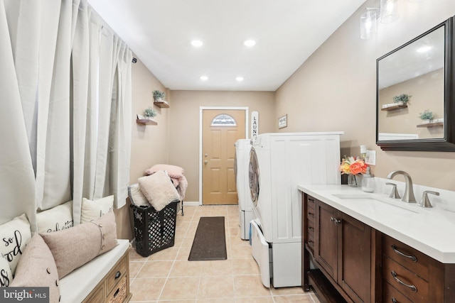 washroom with recessed lighting, stacked washer / dryer, light tile patterned flooring, a sink, and laundry area