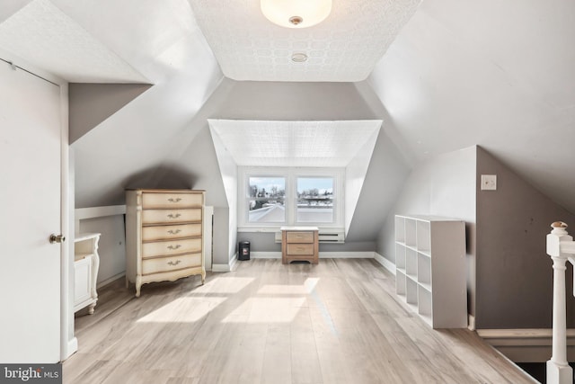 bonus room with light wood-style floors, vaulted ceiling, and baseboards