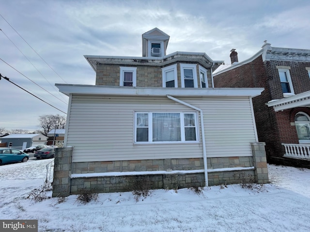 view of snow covered back of property