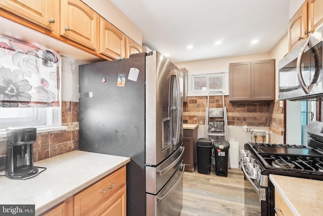 kitchen featuring recessed lighting, stainless steel appliances, light countertops, light wood-type flooring, and decorative backsplash