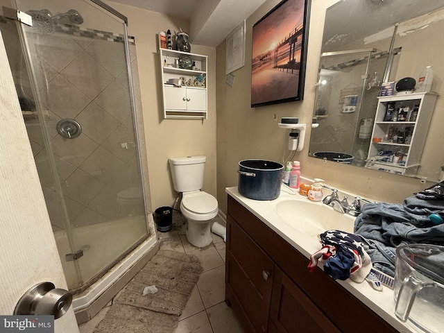 bathroom featuring tile patterned floors, toilet, vanity, and an enclosed shower