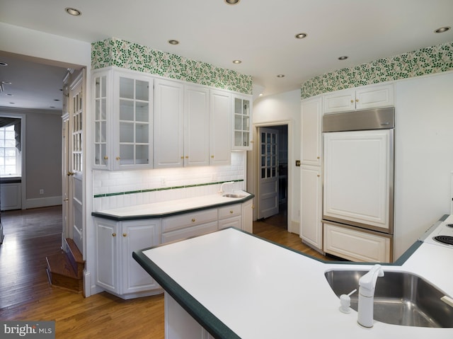 kitchen featuring white cabinetry, dark hardwood / wood-style flooring, paneled fridge, and tasteful backsplash