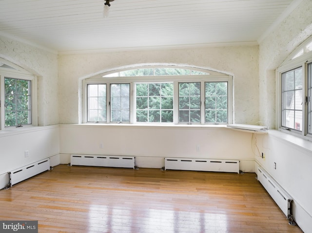 spare room with crown molding, light wood-type flooring, and baseboard heating