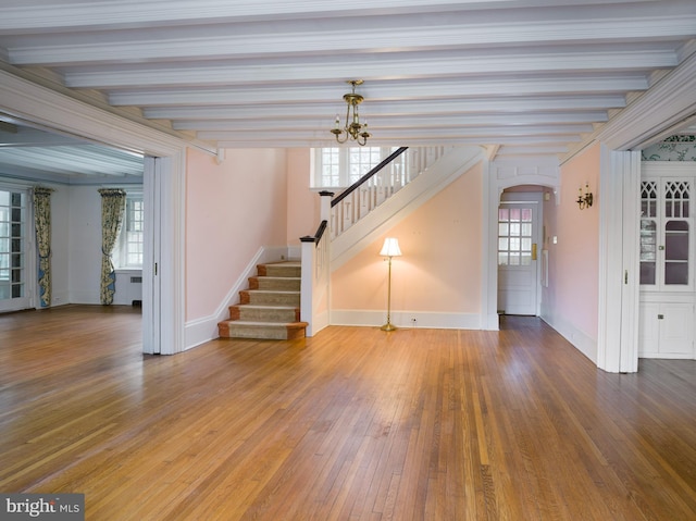 unfurnished living room with beamed ceiling, wood-type flooring, and a notable chandelier