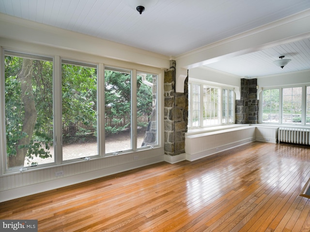 spare room with radiator heating unit, wood ceiling, and light wood-type flooring