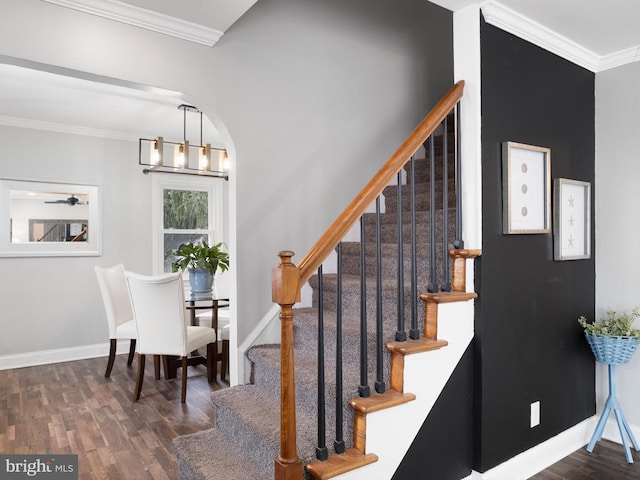 interior space featuring dark wood-type flooring, ornamental molding, and a chandelier