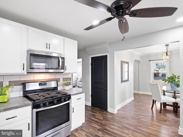 kitchen with ceiling fan, stainless steel appliances, decorative backsplash, and white cabinetry