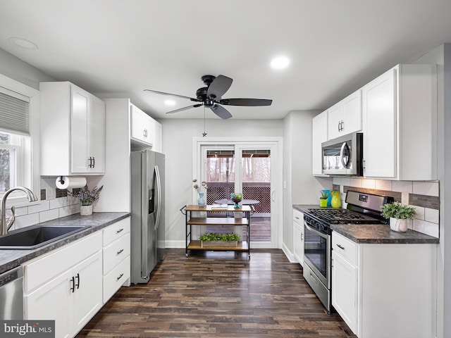 kitchen with appliances with stainless steel finishes, sink, and white cabinetry