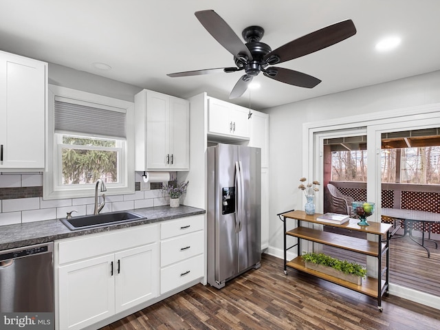 kitchen with white cabinetry, stainless steel appliances, sink, backsplash, and dark hardwood / wood-style floors