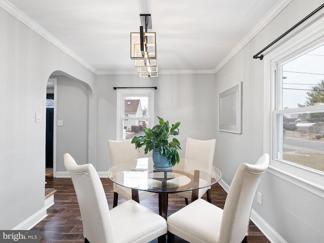 dining area with crown molding, a healthy amount of sunlight, dark hardwood / wood-style floors, and a notable chandelier