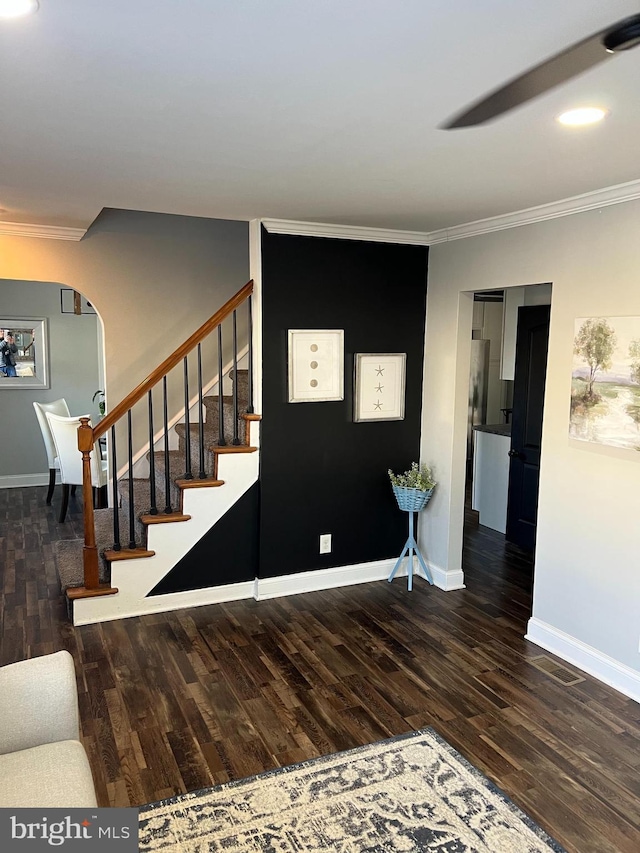 stairway with ornamental molding and hardwood / wood-style floors