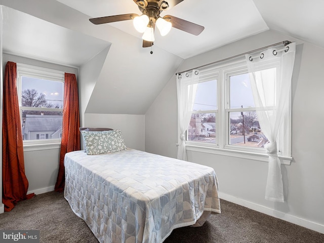 carpeted bedroom with ceiling fan, multiple windows, and lofted ceiling