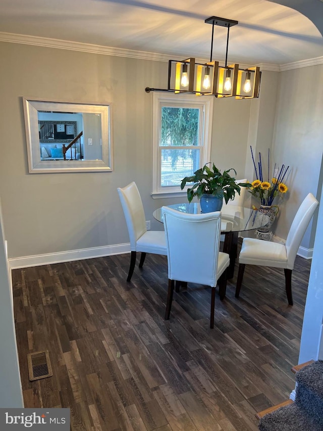 dining space featuring dark hardwood / wood-style flooring and ornamental molding