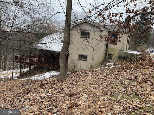 view of snowy exterior featuring a wooden deck