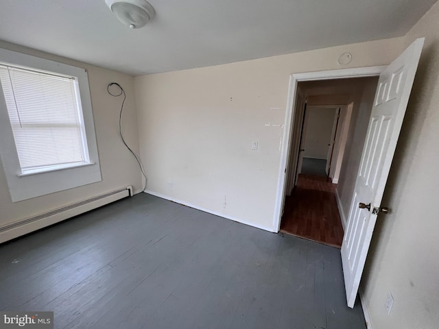 unfurnished room with a baseboard radiator and dark hardwood / wood-style flooring