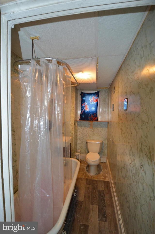 bathroom featuring toilet, shower / bath combo with shower curtain, and hardwood / wood-style floors