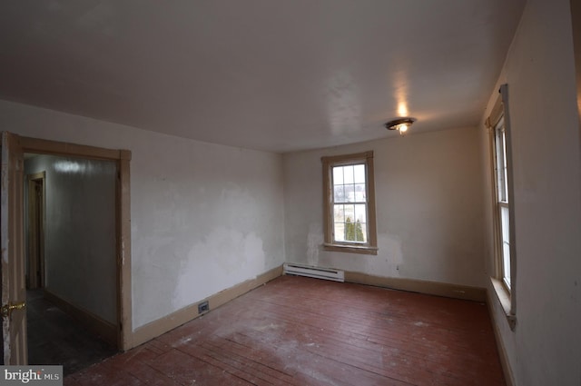 spare room featuring a baseboard heating unit and hardwood / wood-style floors