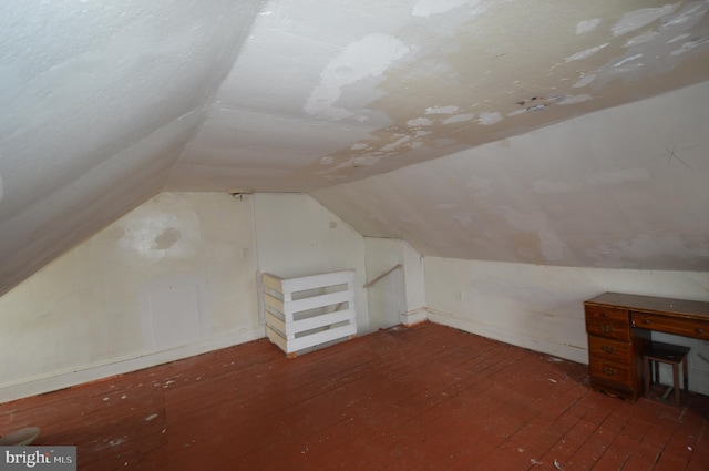 bonus room with vaulted ceiling and dark hardwood / wood-style floors