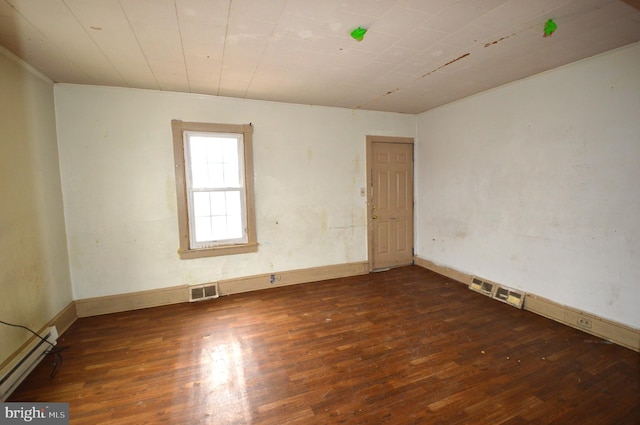 empty room with dark wood-type flooring and a baseboard radiator