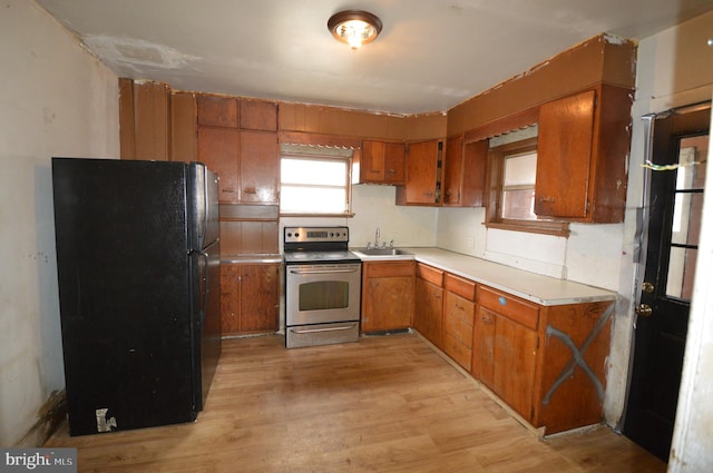 kitchen featuring sink, black refrigerator, electric range, and light wood-type flooring