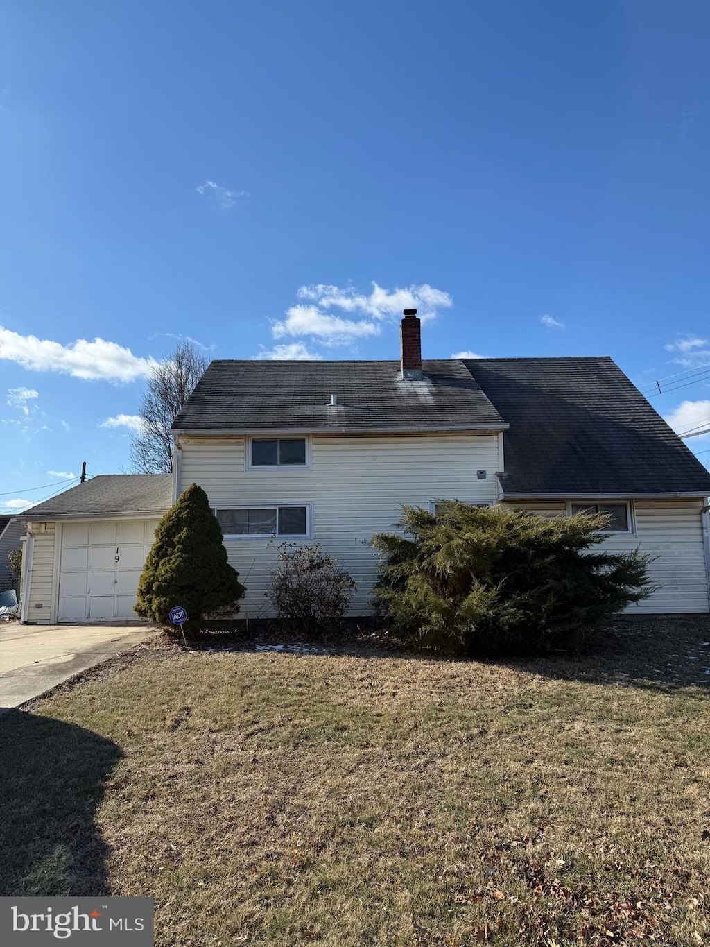 view of property exterior featuring a garage and a lawn