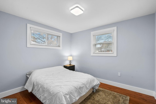 bedroom featuring dark wood-type flooring and multiple windows