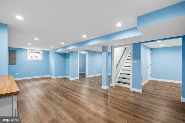 basement with electric panel and dark hardwood / wood-style flooring