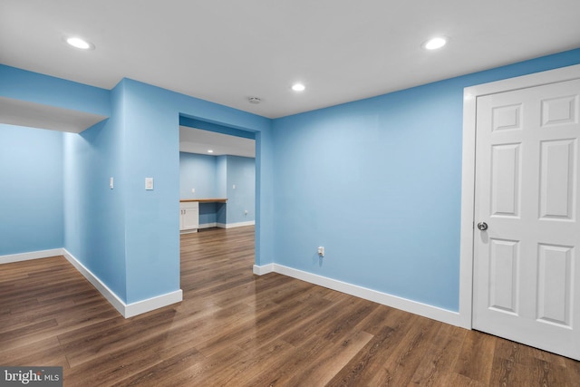 empty room with built in desk and dark hardwood / wood-style flooring