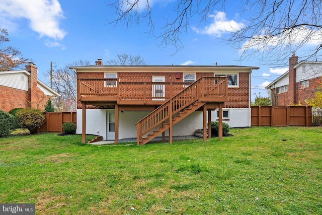 rear view of house featuring a yard and a wooden deck