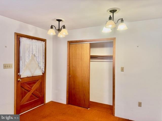 unfurnished bedroom featuring a closet, a notable chandelier, and light colored carpet