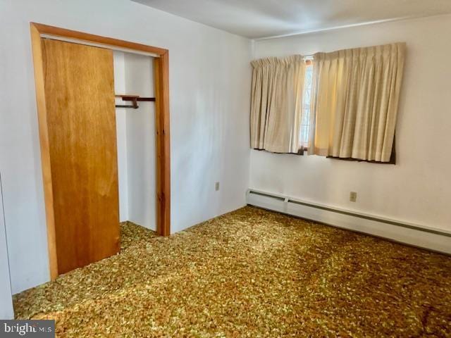 unfurnished bedroom featuring a baseboard radiator and a closet