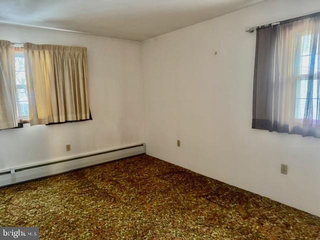 unfurnished room with a baseboard heating unit