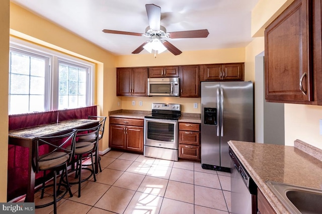 kitchen featuring stainless steel appliances, sink, ceiling fan, and light tile patterned floors