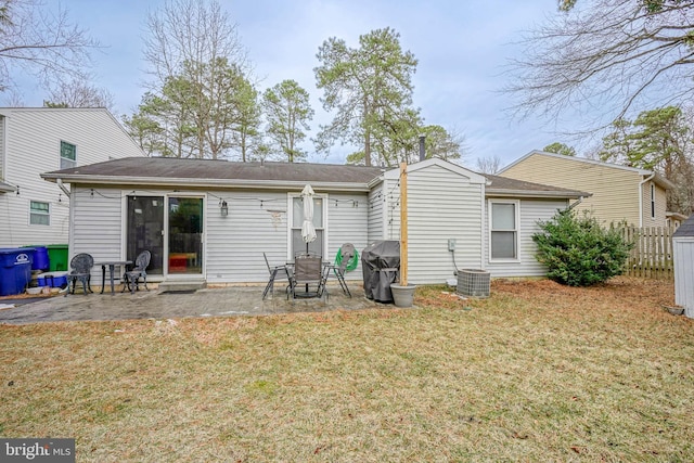 rear view of property featuring a patio area, central AC unit, and a lawn