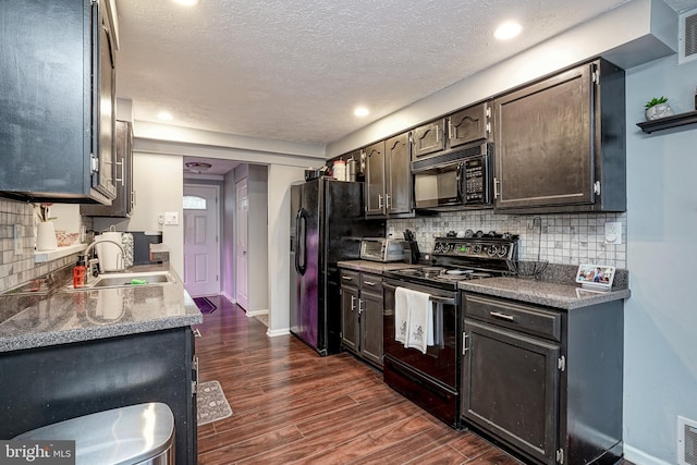 kitchen with black appliances, backsplash, dark hardwood / wood-style floors, and sink