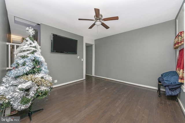 living room with dark hardwood / wood-style floors and ceiling fan