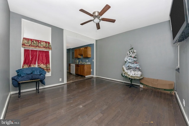 sitting room with dark wood-type flooring, sink, and ceiling fan