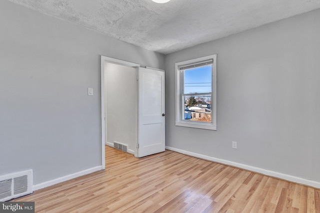 unfurnished bedroom featuring a textured ceiling and light wood-type flooring