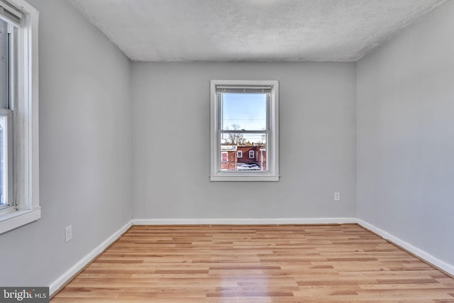 unfurnished room featuring a textured ceiling and light hardwood / wood-style floors