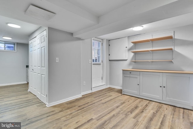 basement with light hardwood / wood-style flooring