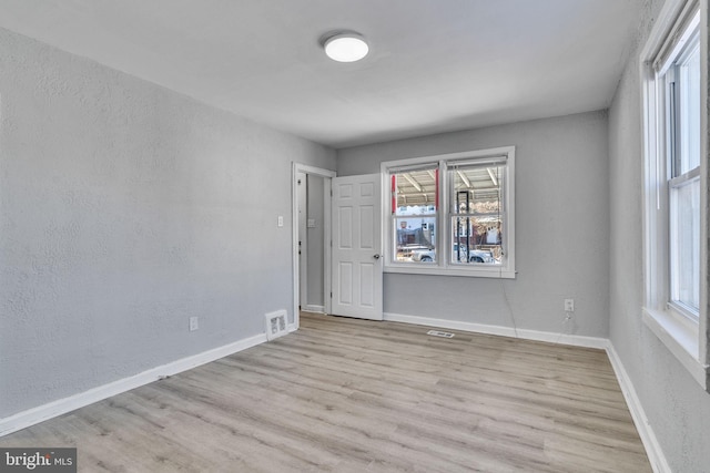 unfurnished room with light wood-type flooring