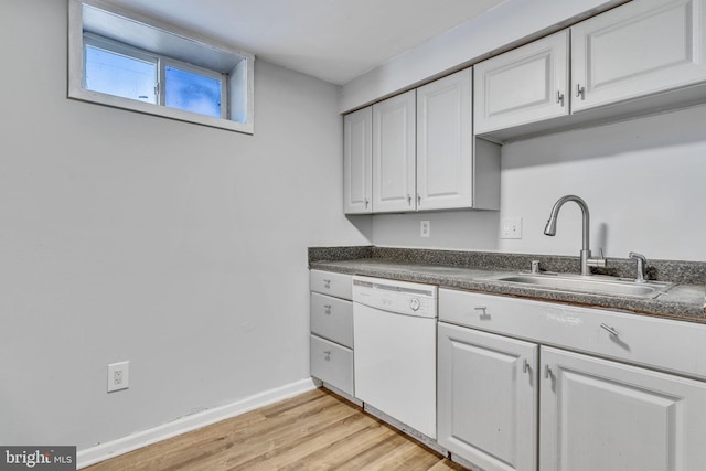 kitchen featuring white dishwasher, sink, light hardwood / wood-style flooring, and white cabinetry