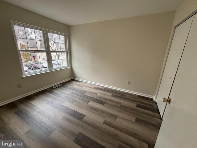 empty room with dark wood-type flooring