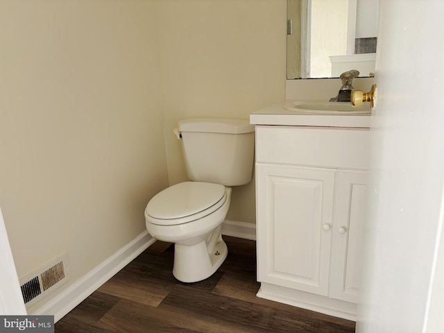 bathroom featuring toilet, vanity, and hardwood / wood-style floors