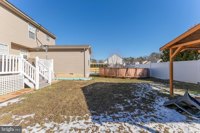 yard covered in snow with a pool side deck